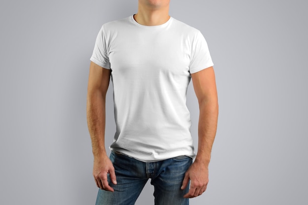 Man in a white t-shirt is isolated on a gray wall