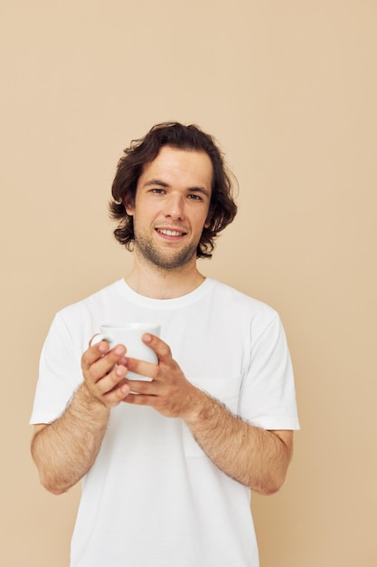 Man in a white Tshirt with a mug in hand isolated background