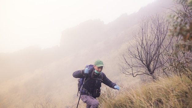 a man who is cheerfully climbing a mountain