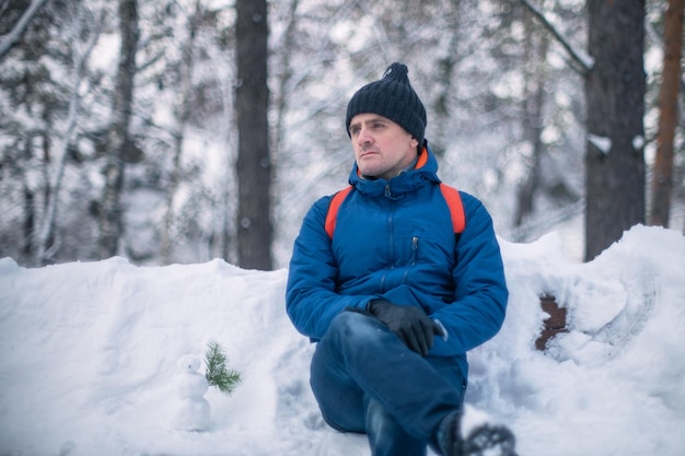 Man in winter jacket walking in snowy winter forest snowy winter day