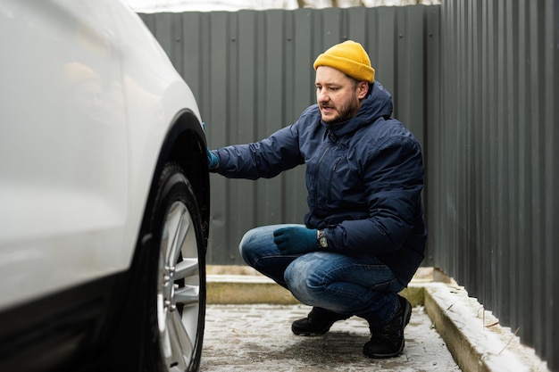 Man wipes american SUV car with a microfiber cloth after washing in cold weather