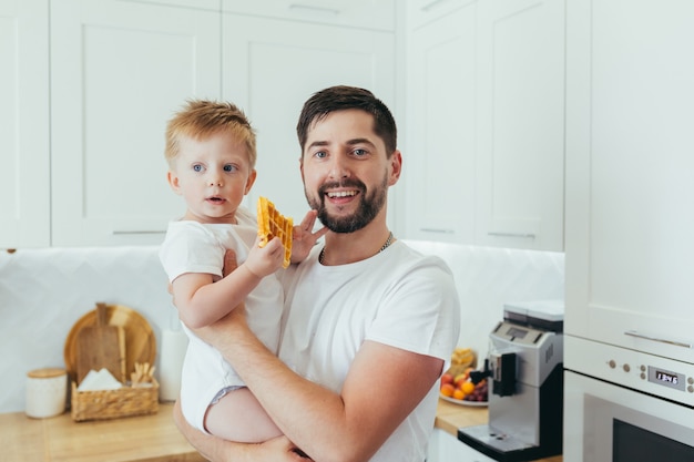 A man with a baby boy prepares breakfast, a father and a son