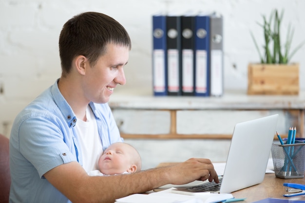 Man with a baby and a laptop