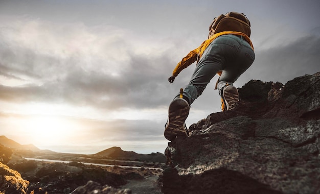 Man with backpack hiking mountain on sunset