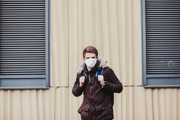 Man with a backpack in a protective mask