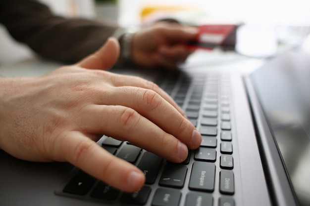 Man with bank card typing on laptop