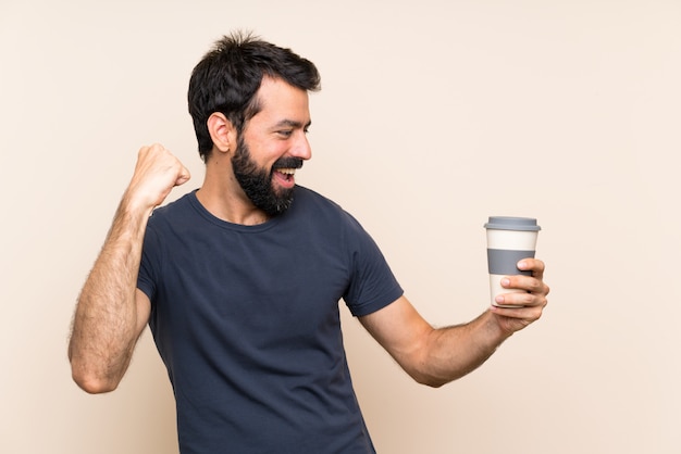 Man with beard holding a coffee celebrating a victory