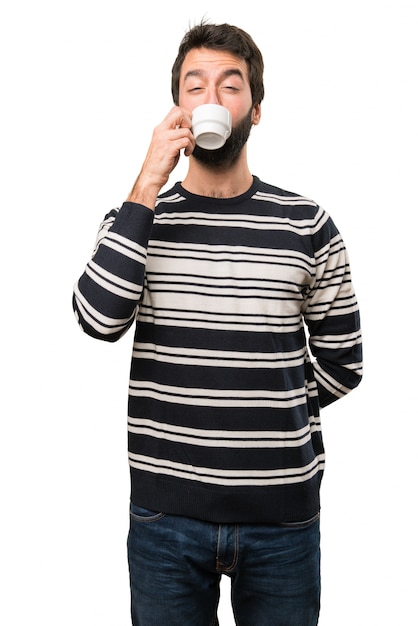 Man with beard holding a cup of coffee