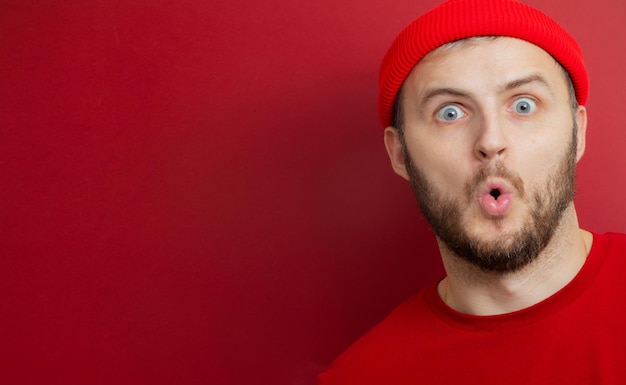 Man with a beard in a red hat opened his mouth in surprise. product advertising. banner