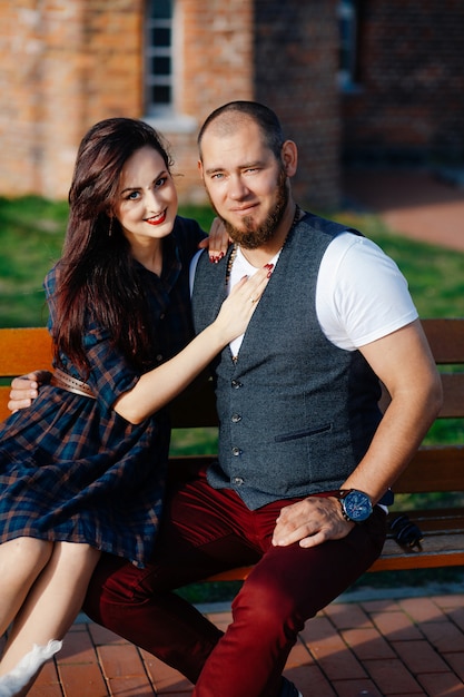 a man with a beard sits on a bench with a beautiful woman