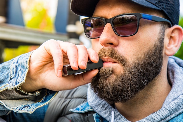 Man with a beard smokes an electronic cigarette