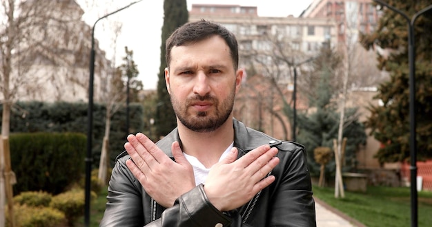 A man with a black leather jacket and a white shirt with the word stop on it