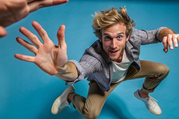 Photo a man with blonde hair and a gray jacket is jumping in the air