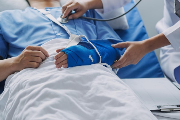 Man with broken arm in cast lying on bed in hospital The emergency center treatment is plaster and hangs with sling for a further cure in an orthopedic clinic Patient pain from accident injury