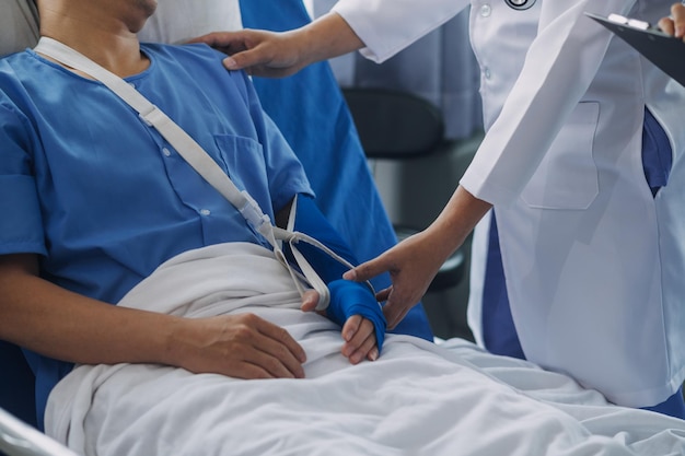 Man with broken arm in cast lying on bed in hospital The emergency center treatment is plaster and hangs with sling for a further cure in an orthopedic clinic Patient pain from accident injury