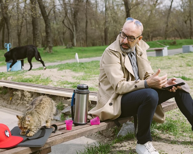 Man with cat and dog in park