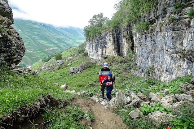 A man with a child on the background of a mountain landscape in the clouds Stone bowl in Dagestan Russia