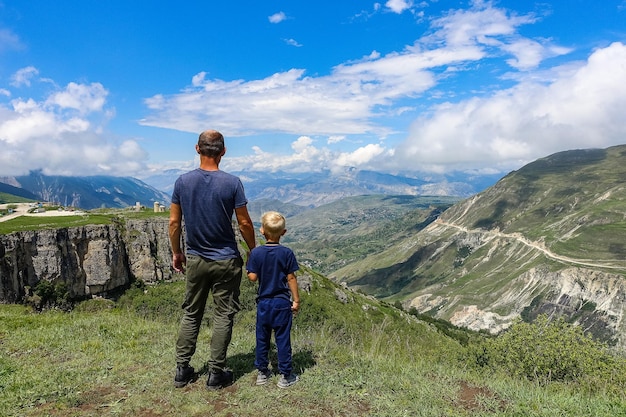 A man with a child on the background of a view of the Matlas plateau Khunzakhsky district Dagestan Russia 2021