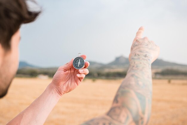 Man with a compass in a mountainous landscape