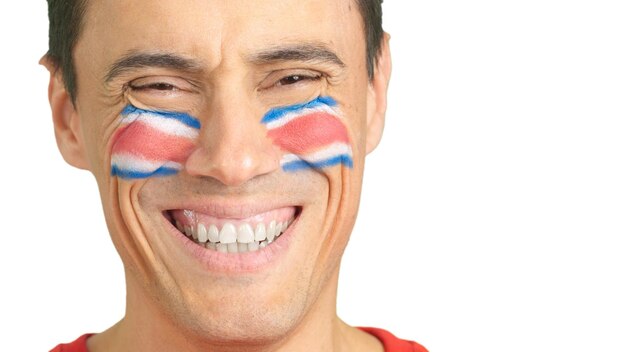 Man with a costa rican flag painted on the face smiling