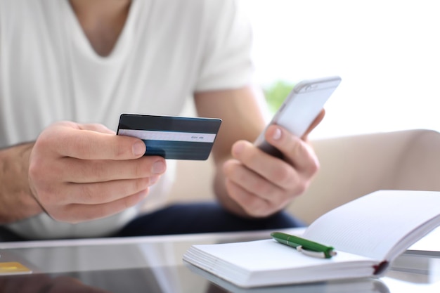 Man with credit card and mobile phone closeup