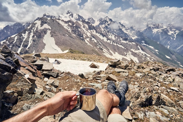 Man with cup in the mountain