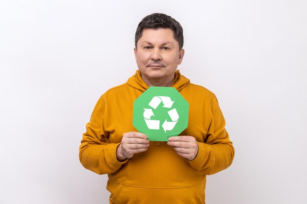 Man with dark hair showing green waste recycling symbol satisfied with environmental safety