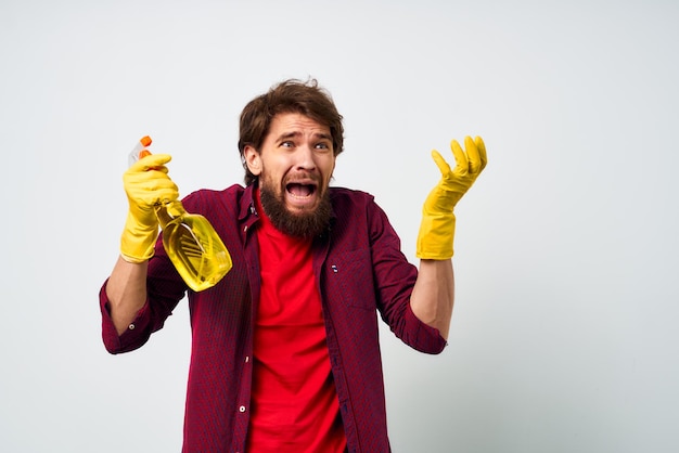 Man with detergent professional cleaning homework light background