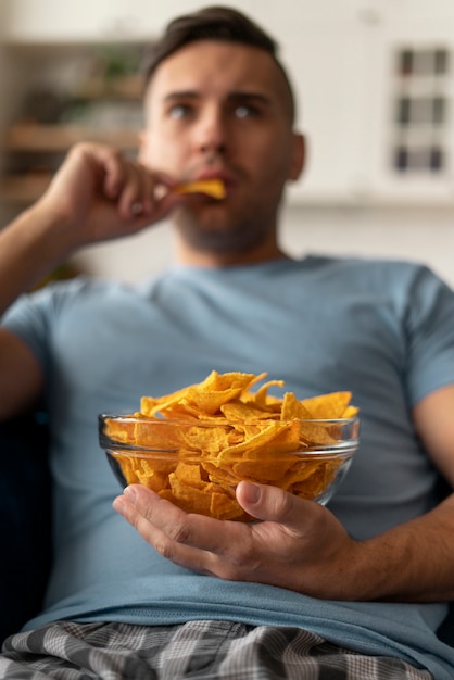 Man with eating disorder trying to eat chips