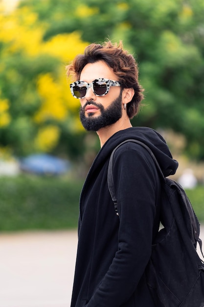 Man with fashionable sunglasses walking outdoors