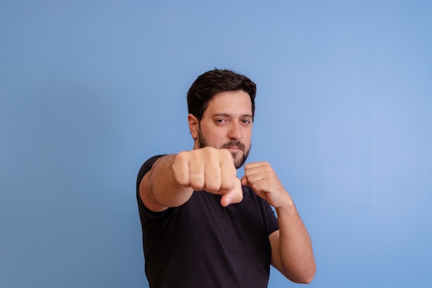 Man with fight gesture on blue