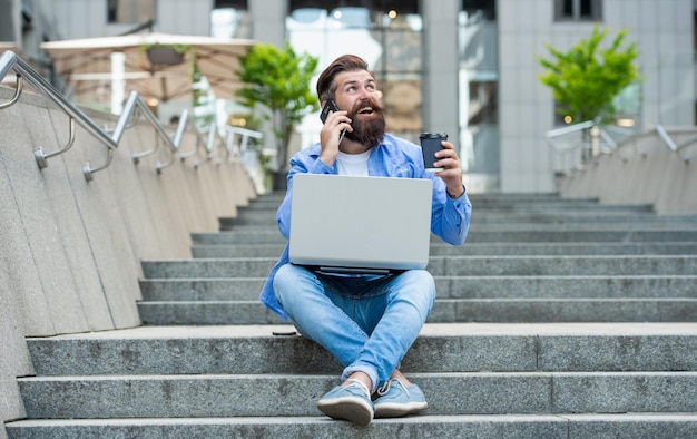 Man with freelance communication talk on phone sit on stairs