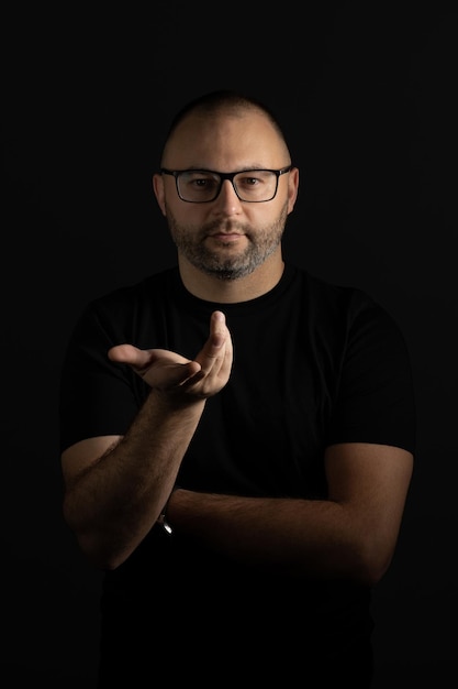 A man with glasses, gesturing questioningly looking at the camera