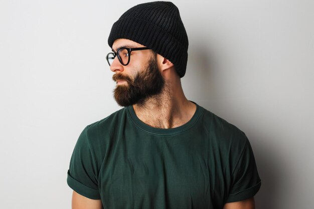 Photo a man with glasses and a green shirt is wearing a hat