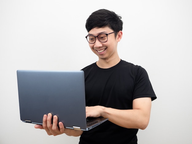 Man with glasses holding laptop and working with happy smile face on white background