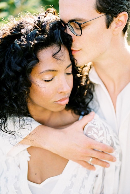 Man with glasses hugs a woman by the shoulders closeup