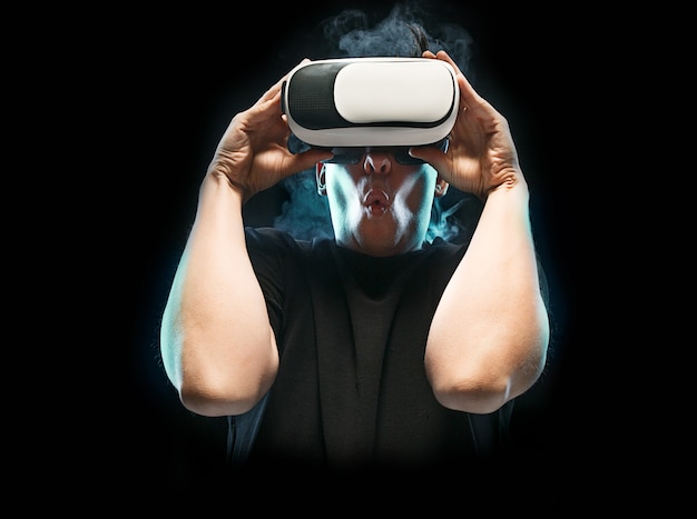 The man with glasses of virtual reality. Future technology concept. Black studio smoky background