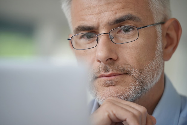 Man with glasses working on a computer                     