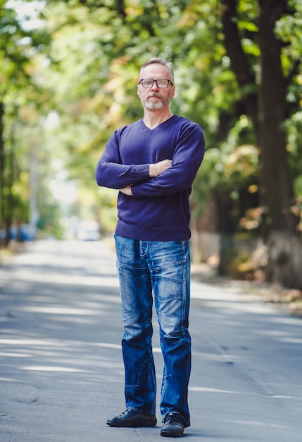 Man with gray hair outdoor in park.