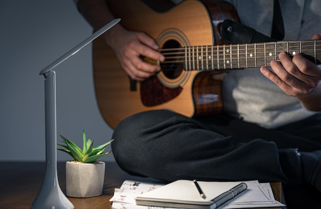 A man with a guitar creates music plays at night