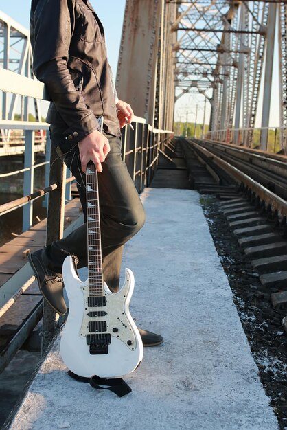 Photo man with a guitar on a railroad