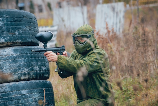 Man with gun playing at paintball. Outdoors