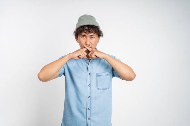 Man with hands covering mouth standing over isolated background