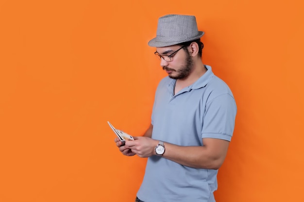 Man with hat beard and glasses counting money euros on orange background