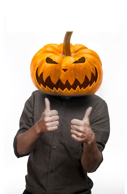 Man with the head of a pumpkin in a jacket stand with the thumb up