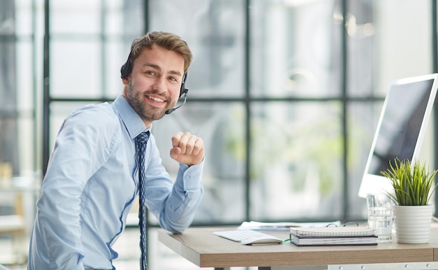 Man with headphones and laptop working in office