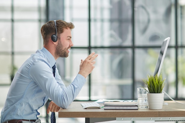 Man with headphones and laptop working in office