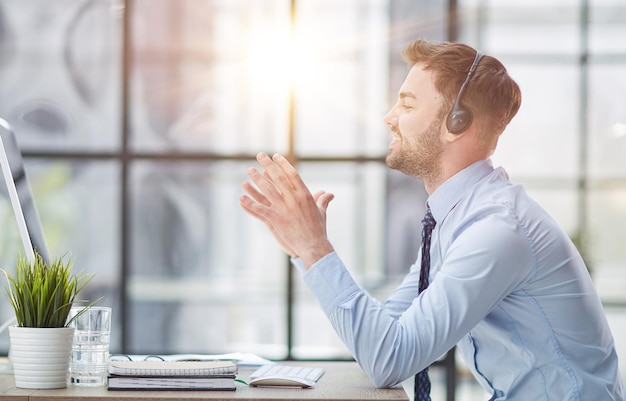 Man with headphones and laptop working in office