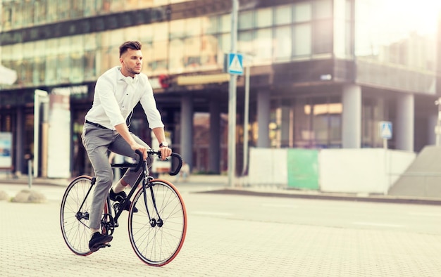 Photo man with headphones riding bicycle on city street