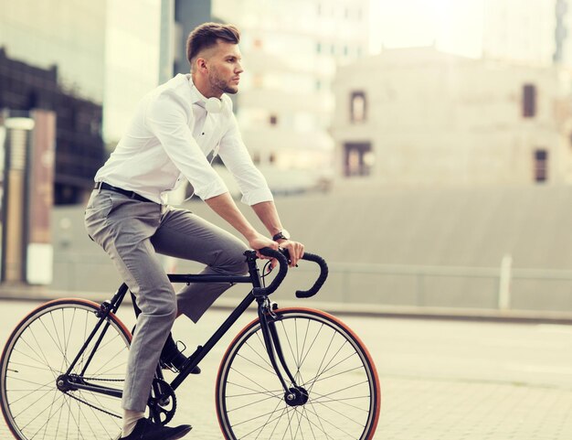 Photo man with headphones riding bicycle on city street